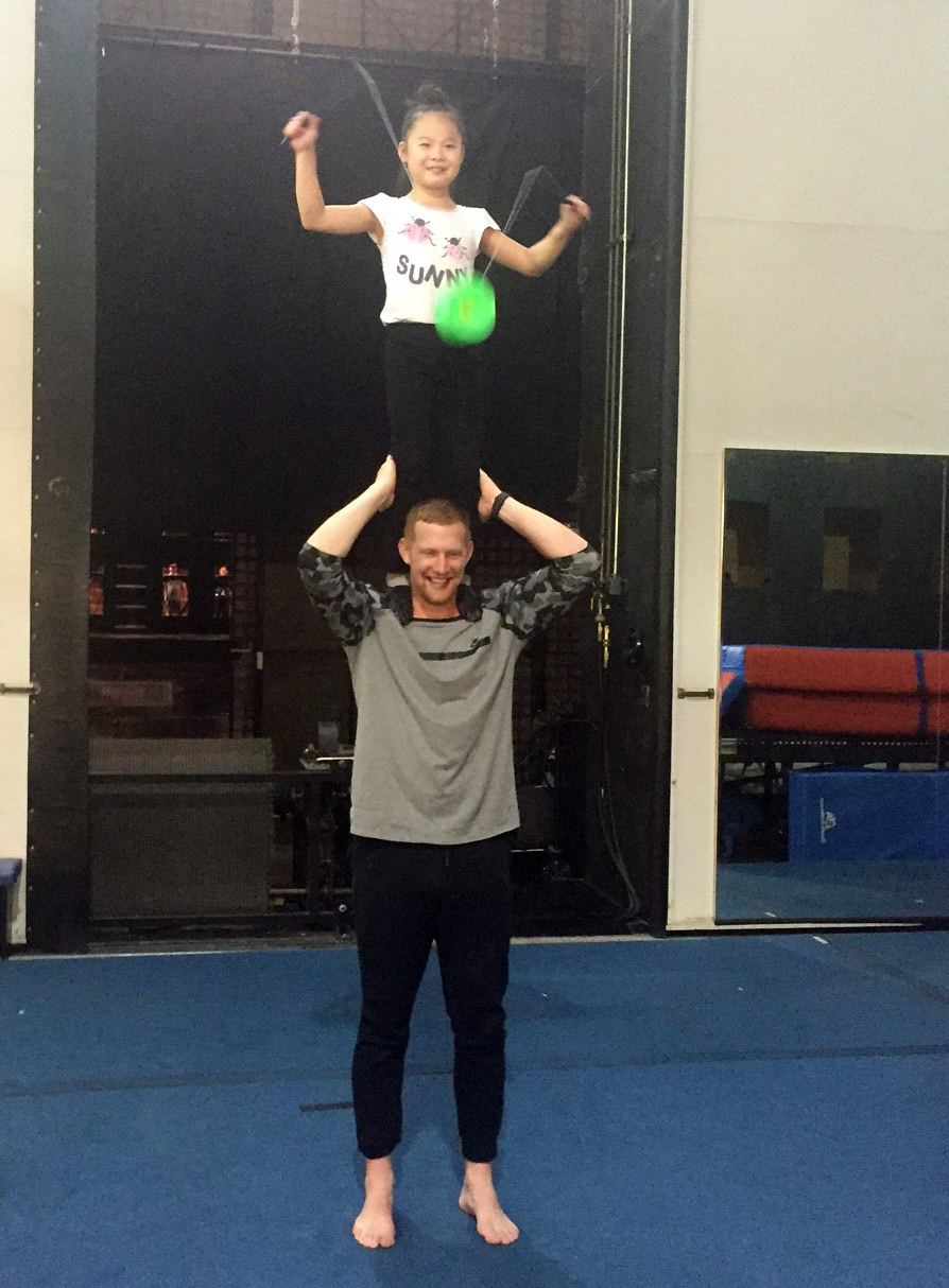Los Angeles Rams Punter Johnny Hekker attempts a stunt from La Nouba with a member of the Chinese yo-yo troupe backstage at La Nouba by Cirque du Soleil