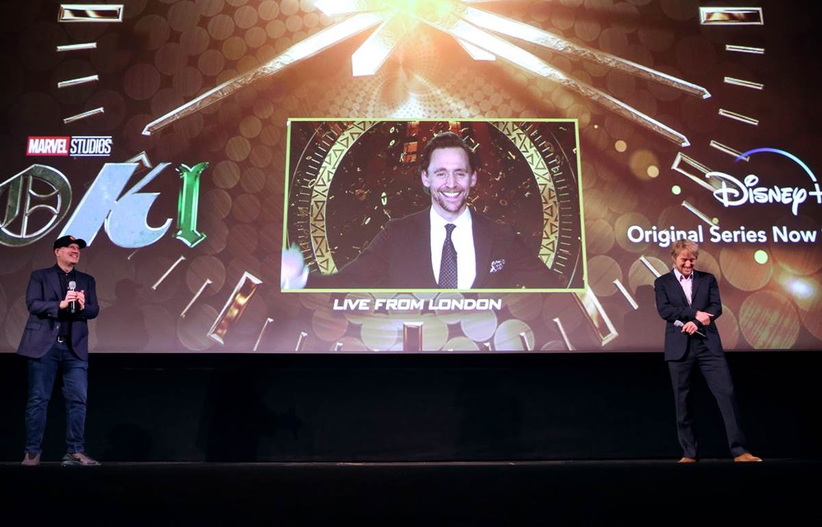LOS ANGELES, CALIFORNIA - JUNE 08: (L-R) Kevin Feige, Tom Hiddleston (via satellite from London), and Owen Wilson speak onstage during the Loki Global Fan Event at El Capitan Theatre on June 08, 2021 in Los Angeles, California. (Photo by Jesse Grant/Getty Images for Disney )
