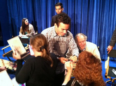 The cast signs autographs following the panel