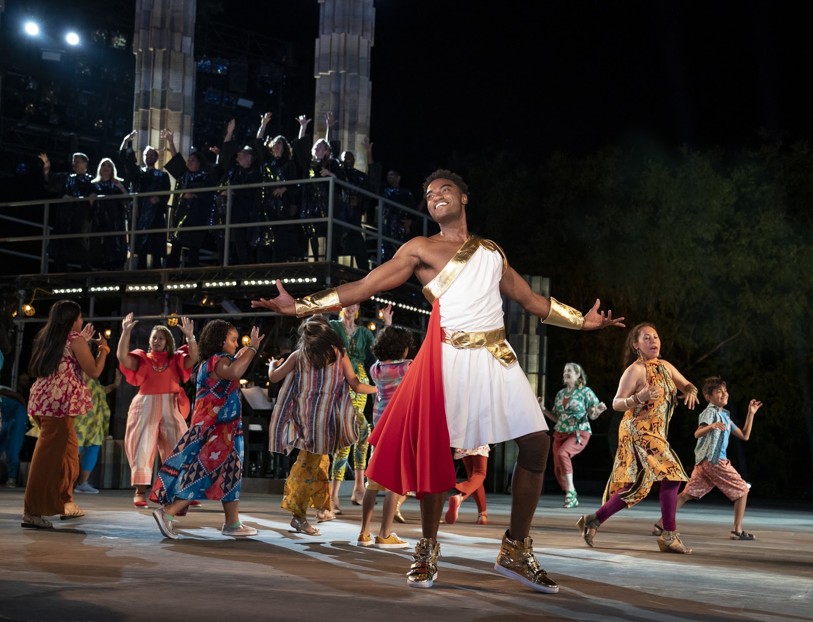 Jelani Alladin (foreground) and the company of The Public Theater’s free Public Works musical adaptation of Hercules, with music by Alan Menken, lyrics by David Zippel, book by Kristoffer Diaz, choreography by Chase Brock, and directed by Lear deBessonet, running at the Delacorte Theater. Photo credit: Joan Marcus.