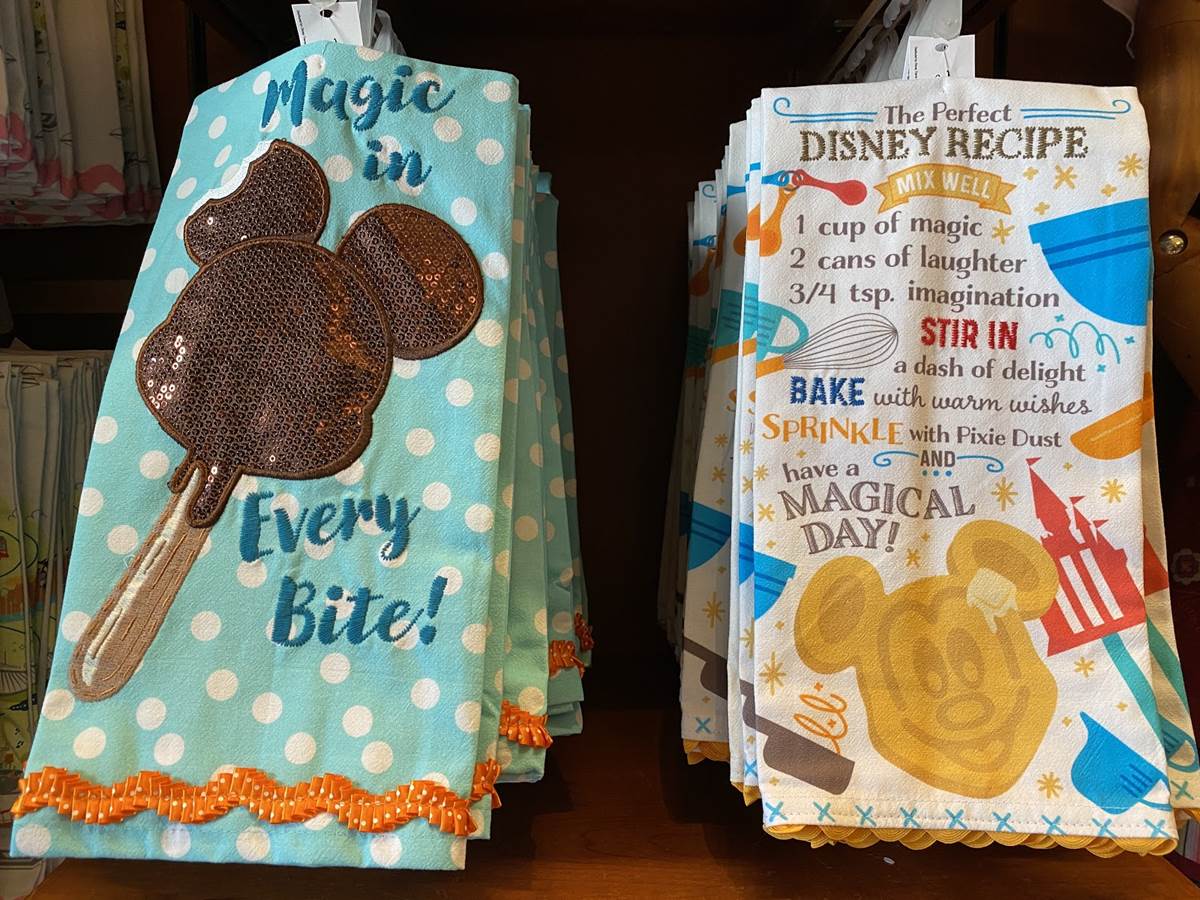 https://www.laughingplace.com/w/wp-content/uploads/2021/01/disneyland-themed-kitchen-towels-and-aprons-appear-on-buena-vista-street-1.jpeg