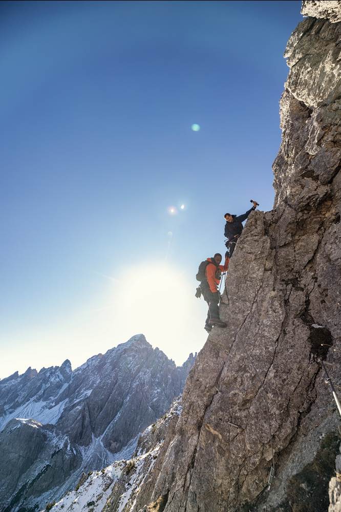 Bear Grylls and Anthony Mackie climb a via ferrata. (National Geographic/Ben Simms)
