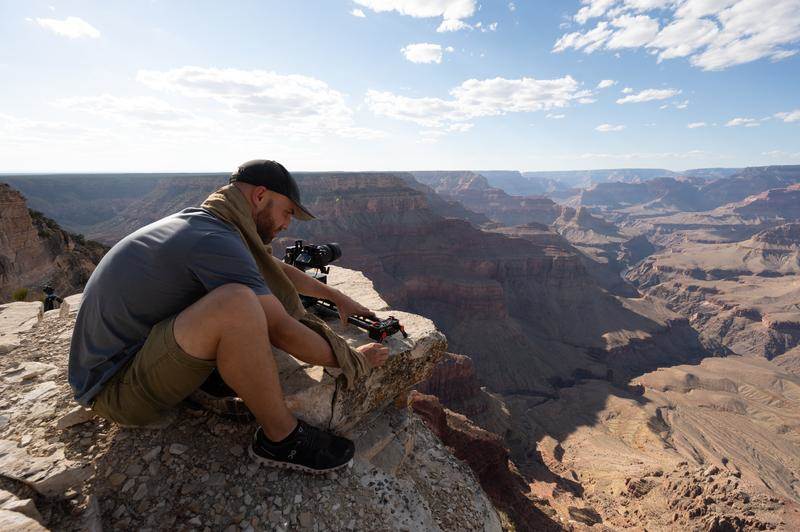 Camera Operator filming over the rim of the Grand Canyon. 
(National Geographic/Taylor Gray)