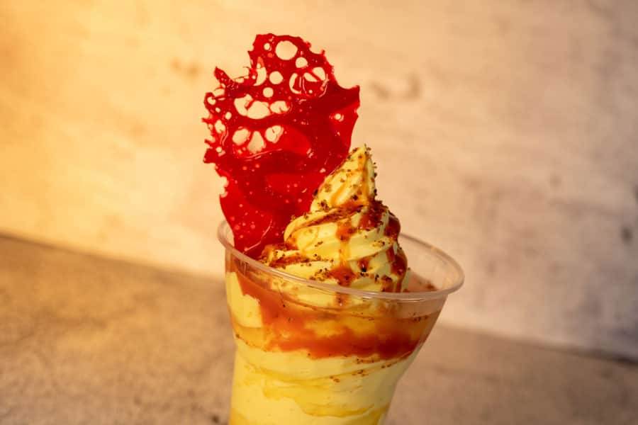 DOLE Whip mango with Chamoy-mango purée and topped with chili-lime seasoning, red bubble sugar, and pineapple juice
